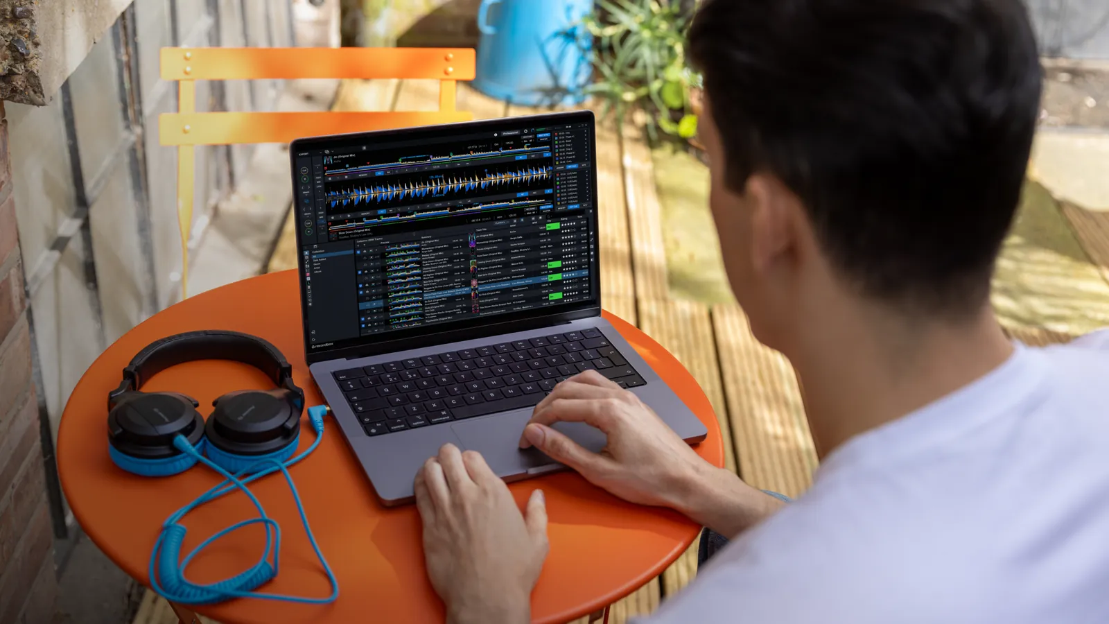 Un DJ preparando su biblioteca en rekordbox en un portátil, con unos auriculares al lado